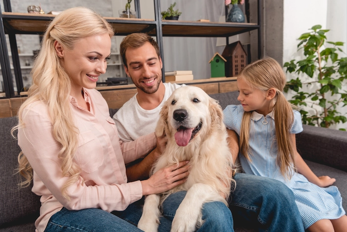 Parents with daughter playing with their adopted dog
