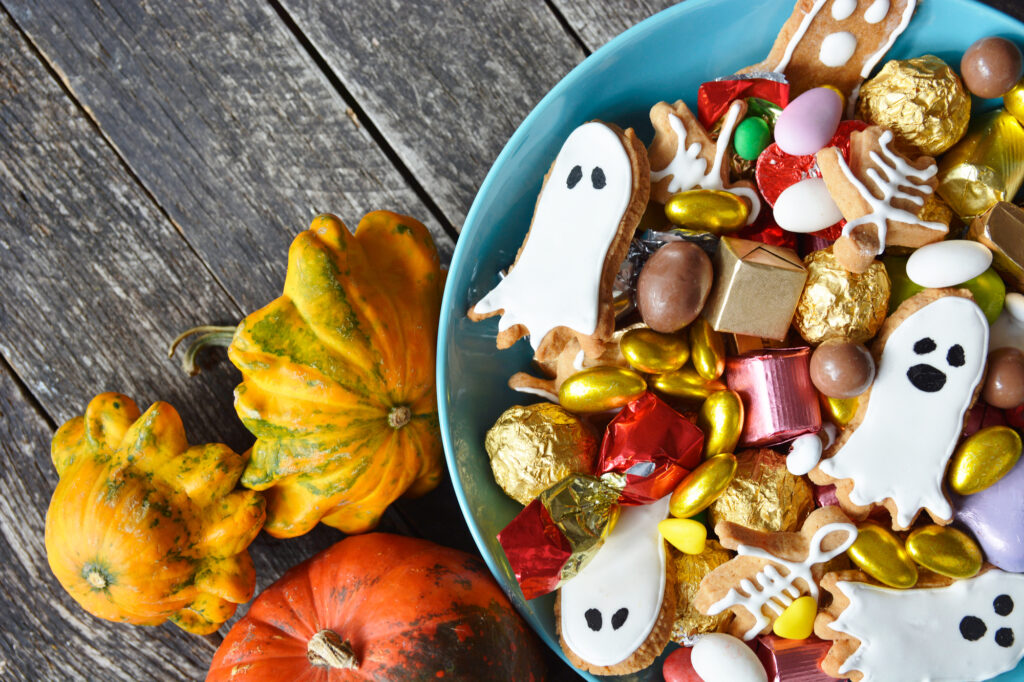 Halloween Jack-o-Lantern candy bowl with pumpkin sweets.